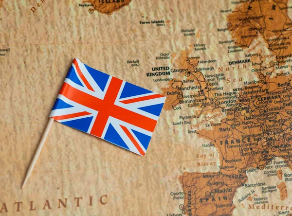 stock image the national union jack flag of great britian ,blue and red on world map,travel concept