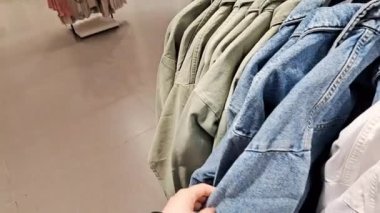 Alışveriş merkezinde elbise seçen bir kadın.