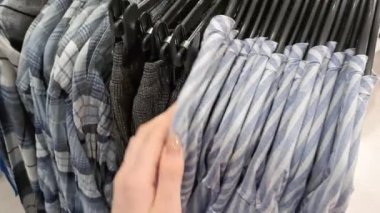 Alışveriş merkezinde elbise seçen bir kadın.