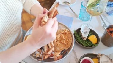 Deniz ürünleri restoranında yengeç soyan bir kadının elleri.