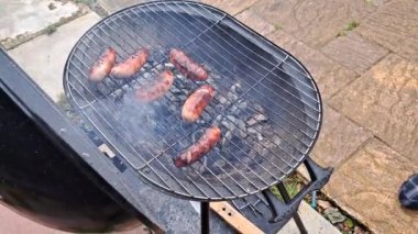 Et sosisleri ızgarada kızarıyor, bahçede barbekü yapıyor, hafta sonunu geçiriyor. Yüksek kalite 4k görüntü