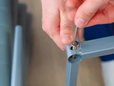 Tamirat için aletler kullanarak mobilya montajı yapan tamirci..