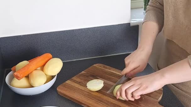 女性の手は台所で生のタマネギを切断します — ストック動画