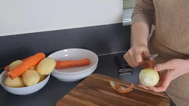 女性の手は 台所で生の玉ねぎを剥離 夕食の料理 — ストック動画