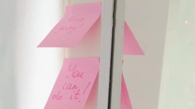 Aynadaki pembe etiket üzerinde ilham verici alıntılar, el yazısı metni.