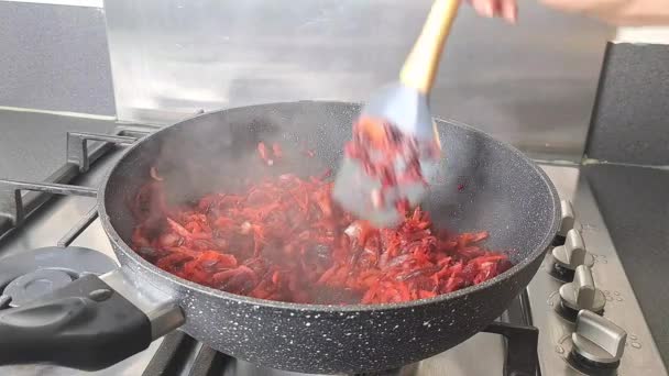 女人的手把烤蔬菜和洋葱 甜菜和胡萝卜混合在油锅里 高质量的4K镜头 — 图库视频影像