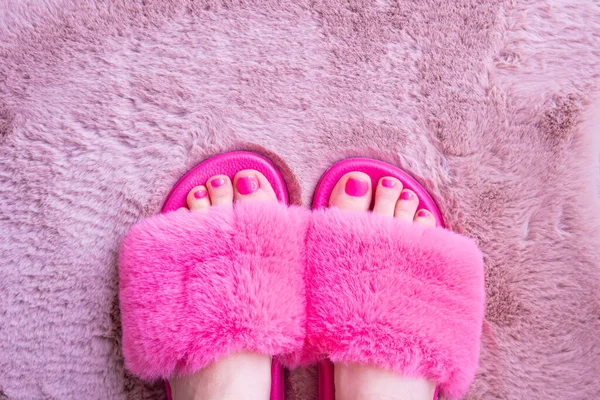 Ноги Розовых Тапочках Мехового Домика Порошковом Ковре — стоковое фото