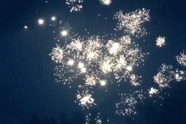 Gece mavi gökyüzünde şenlikli, ışıl ışıl havai fişekler. Yüksek kaliteli FullHD görüntüler