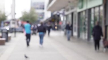 Şehrin işlek caddesinde yürüyen insanlarla dolu bulanık bir arka plan. Yüksek kalite 4k görüntü
