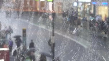 Kalabalık kalabalık caddelerde yağmurlu bir günde, şemsiye altında, pencere manzarasından