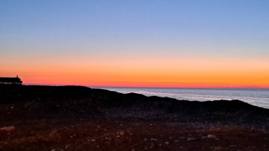 Güneş ufkun altına batıyor. Huzurlu denizde sıcak altın bir parıltı yayıyor.