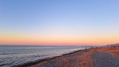 Güneş ufkun altına batıyor. Huzurlu denizde sıcak altın bir parıltı yayıyor.