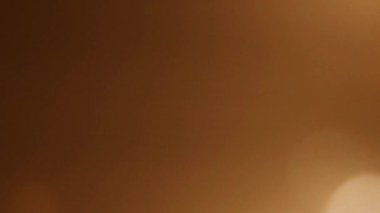 Zengin kahverengi ve altın bokeh arkaplan, tasarımlarınıza sıcaklık ve derinlik eklemek için mükemmel.