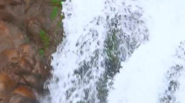 Şelaleler dağ uçurumlarından aşağı dökülüyor, doğada manzaralı güzellikler sunuyor..