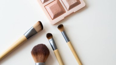 Beyaz arka planda tahta organik makyaj fırçaları. Çevre dostu, sürdürülebilir güzellik araçları.