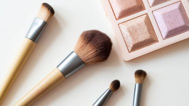 Beyaz arka planda tahta organik makyaj fırçaları. Çevre dostu, sürdürülebilir güzellik araçları.