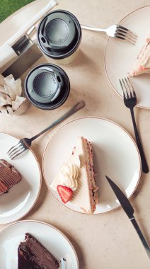 Kafe masasında nefis kremalı kekler, rahat bir ortamda kahvaltı için mükemmel. Yüksek kalite fotoğraf