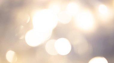 Yumuşak, parıldayan ışıklarla altın renkli arka plan sıcak, rüya gibi ve zarif bir ortam yaratıyor.