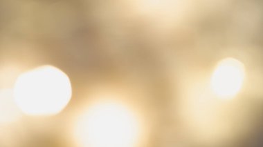 Yumuşak, parıldayan ışıklarla altın renkli arka plan sıcak, rüya gibi ve zarif bir ortam yaratıyor.