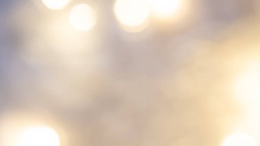 Yumuşak, parıldayan ışıklarla altın renkli arka plan sıcak, rüya gibi ve zarif bir ortam yaratıyor.