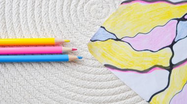 Psikolojik sanat terapisinde kullanılan beyaz arka planda nörografik çizimler için renkli kalemler..