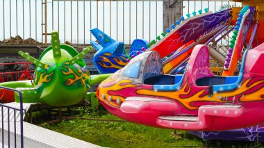 Eğlence parkında kanatlar, yolculuğun neşesini ve heyecanını yakalıyor.