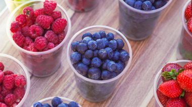 Plastik bardaklarda meyve ve böğürtlen. Sıcak bir gün için mükemmel....