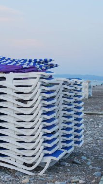 Çakıl taşlı plajda güneşlenirler Yaz akşamının sonunda birbiri ardına