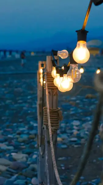 Stock image close up of garland lights in cafe in the summer evening on the beach.