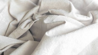 Minimalist beyaz buruşuk kumaş desenli.