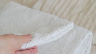 Beyaz ve bej havlular düzgünce istiflenmiş, zarafet ve rahatlık katıyor.