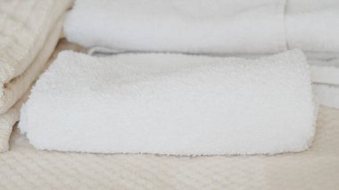 Beyaz ve bej havlular düzgünce istiflenmiş, zarafet ve rahatlık katıyor.