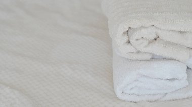 Beyaz ve bej havlular düzgünce istiflenmiş, zarafet ve rahatlık katıyor.