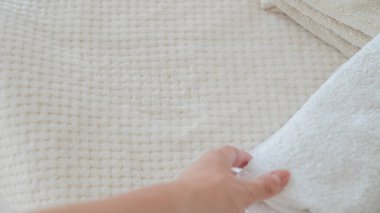 Beyaz ve bej havlular düzgünce istiflenmiş, zarafet ve rahatlık katıyor.