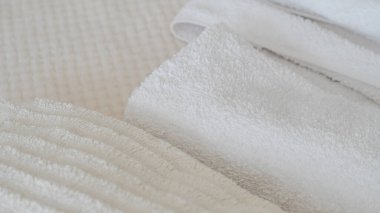 Beyaz ve bej havlular düzgünce istiflenmiş, zarafet ve rahatlık katıyor.