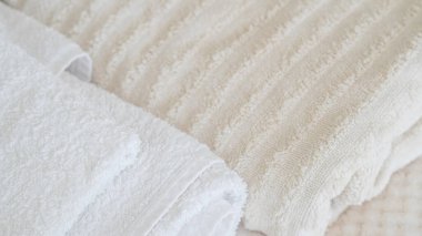 Beyaz ve bej havlular düzgünce istiflenmiş, zarafet ve rahatlık katıyor.
