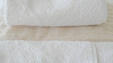 Beyaz ve bej havlular düzgünce istiflenmiş, zarafet ve rahatlık katıyor.