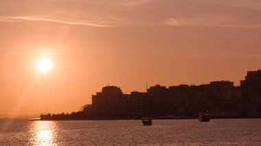 Kahverengi gün batımı deniz manzarası, sakin okyanus dalgaları, ılık kıyı manzarası, altın saat gökyüzü.