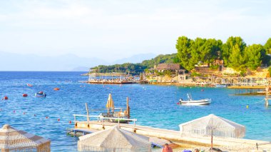 Turkuaz suyu ve altın kumu olan yaz plajı, parlak güneş ışığı altında tatil konsepti..