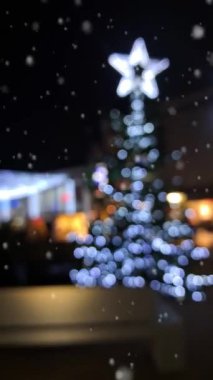 Karlı bir Noel pazarında, neşeli bir atmosferde ışıldayan süslemelerle.