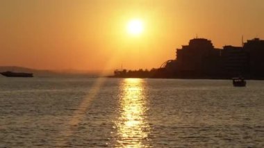 Deniz ve kıyı manzarası sakin turuncu bir günbatımı, yaz sıcacık yurtdışı turları
