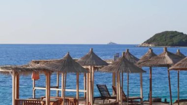 Şemsiyeli plaj, sakin mavi deniz, yaz tatili titreşimleri..