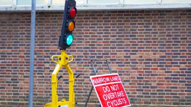 A construction zone with active roadwork and traffic lights regulating the flow clipart