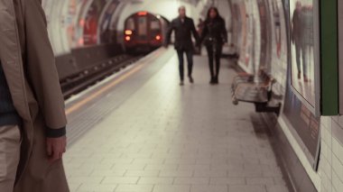 Metroyla metro istasyonu perona geliyor, şehir manzaralı.