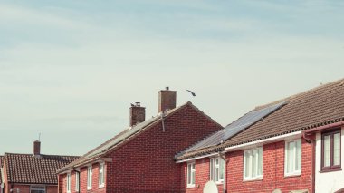 Güneşli bir günde güzel bir köyde kızıl İngiliz evleri kuruluyor.