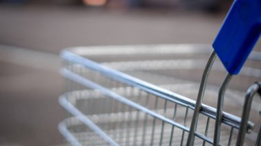 Perakende dükkanının yakınındaki kaldırımda duran bir market arabası.