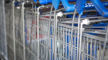 Süpermarket girişinin yakınına yerleştirilmiş yiyecek dolu bir market arabası.