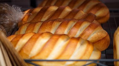 Süpermarket raflarında alıcılar için çeşitli glütensiz ekmekler sergileniyor.