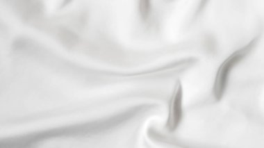 Yumuşak kıvrımları ve hafif ışık yansımaları olan pürüzsüz beyaz ipek kumaş