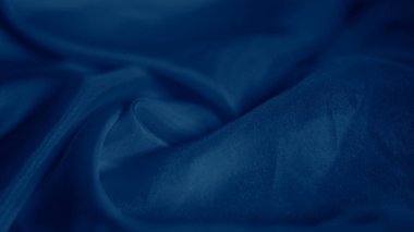Zarif mavi ipek kumaş zarif bir şekilde yanardöner bir ışıltıyla örtülmüş.